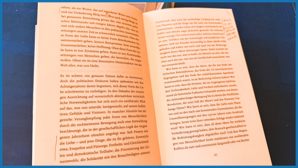 Aufgeschlagenes Buch mit Zitat zu Liebe als politischem Akt: „Diese Form der Liebe kann keine Form demokratischer Zusammenarbeit geben“ – orangefarbene Seiten.