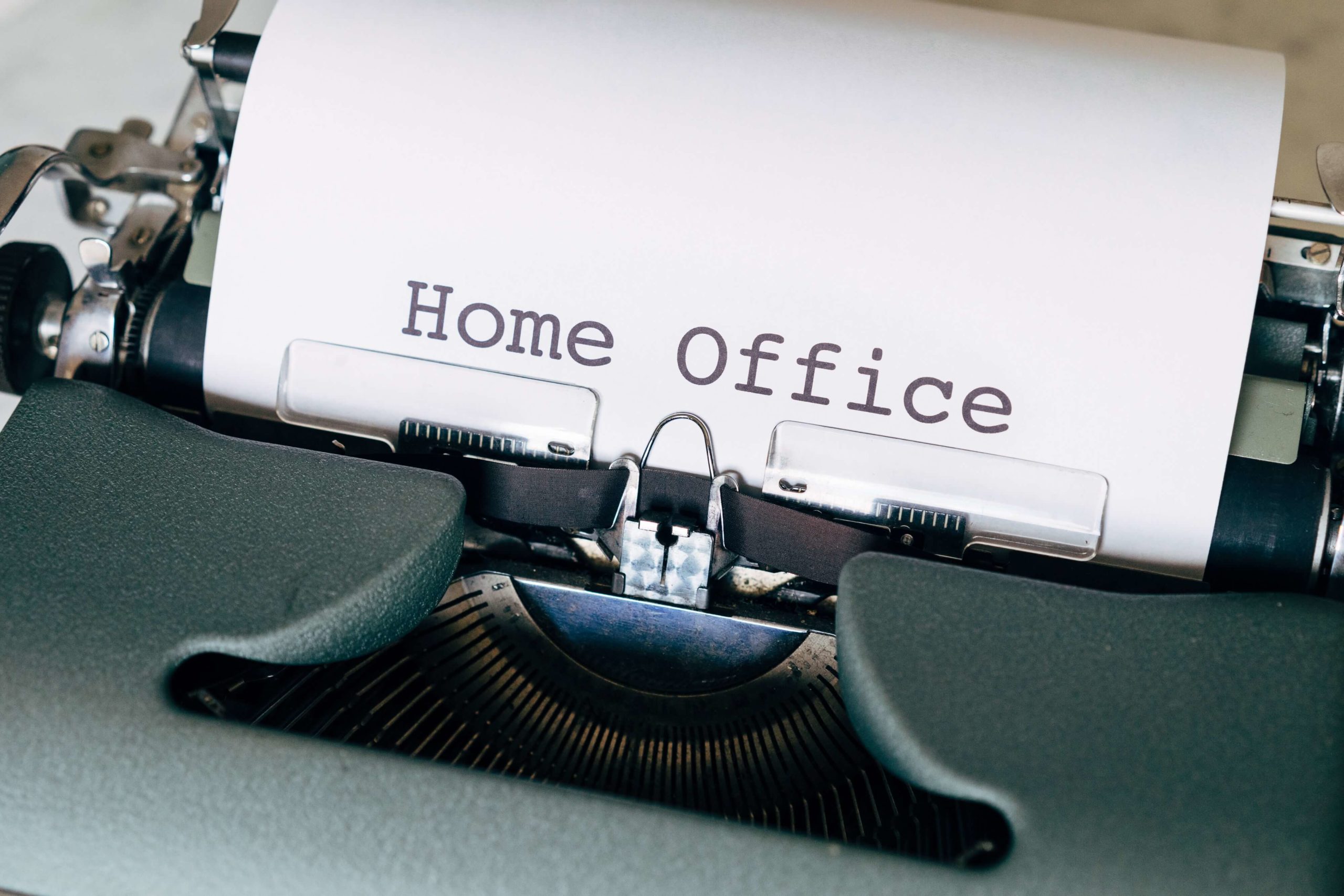 Eine Schreibmaschine mit mit einem Blatt darin, auf dem Home-Office steht.